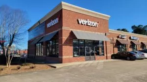 Verizon store in Jasper Alabama showing exterior of red brick building with awnings and storefront windows.