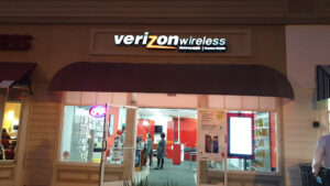 Redwood City, California Verizon store at night with lit up signage and store interior. 