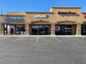 Verizon store exterior in middle of 2 other business within shopping plaza