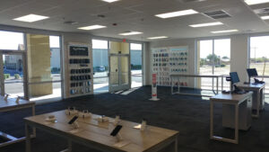 Verizon store interior showing display tables and wall racks with smartphones and protective cases. 