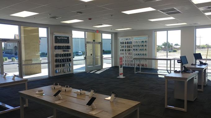 Verizon store interior showing display tables and wall racks with smartphones and protective cases.