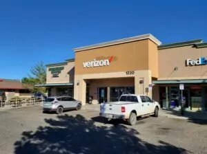 Verizon store in shopping mall with customers vehicles parked outside.
