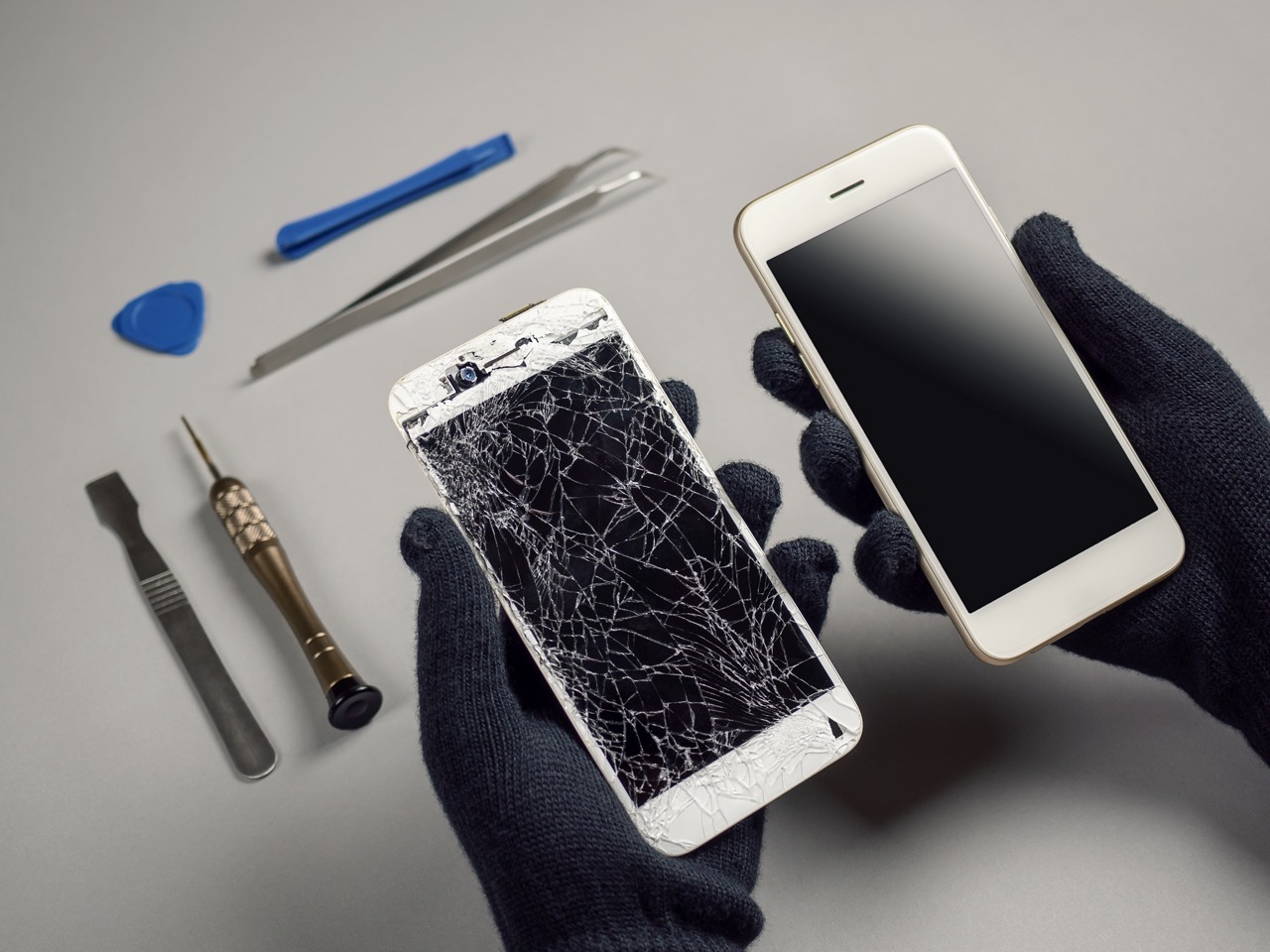 Technician repairing broken smartphone on desk