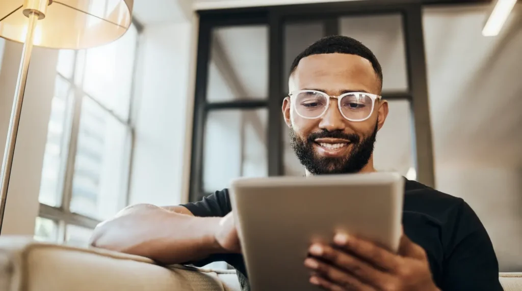 A smiling man using a digital tablet.
