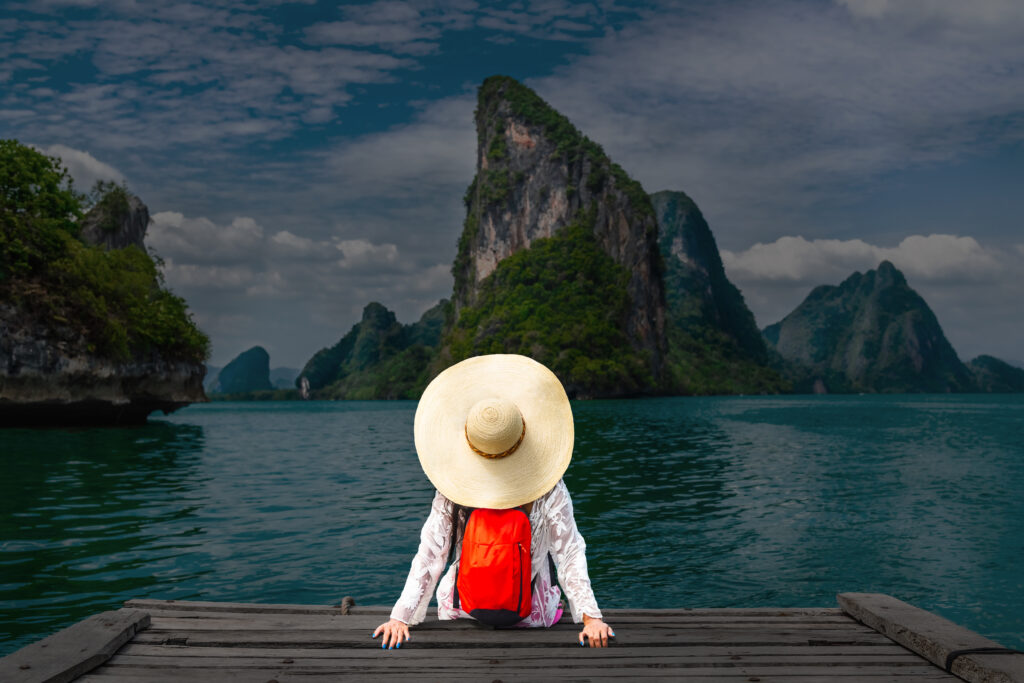 Lady sitting on end of dock looking at beautiful mountain