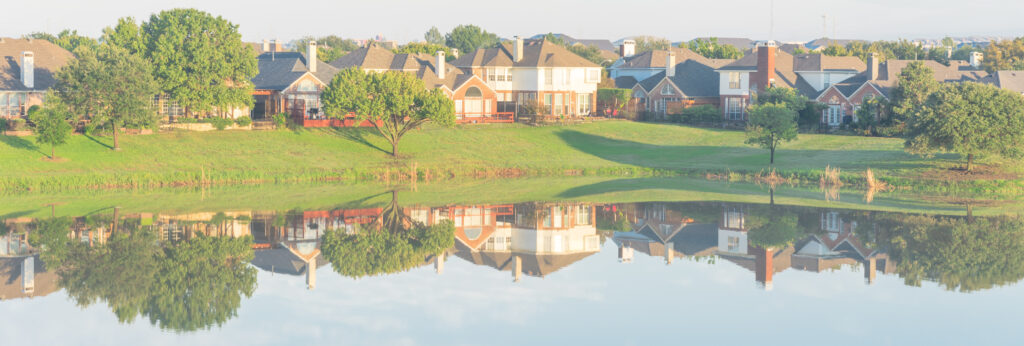 Panoramic view lakeside residential neighborhood row of houses mirror reflection near Dallas, Texas, USA