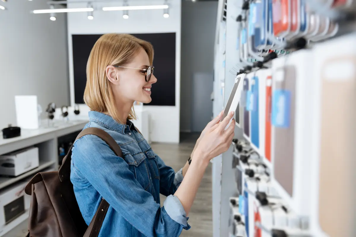A woman browses accessories at a cell phone retail location.