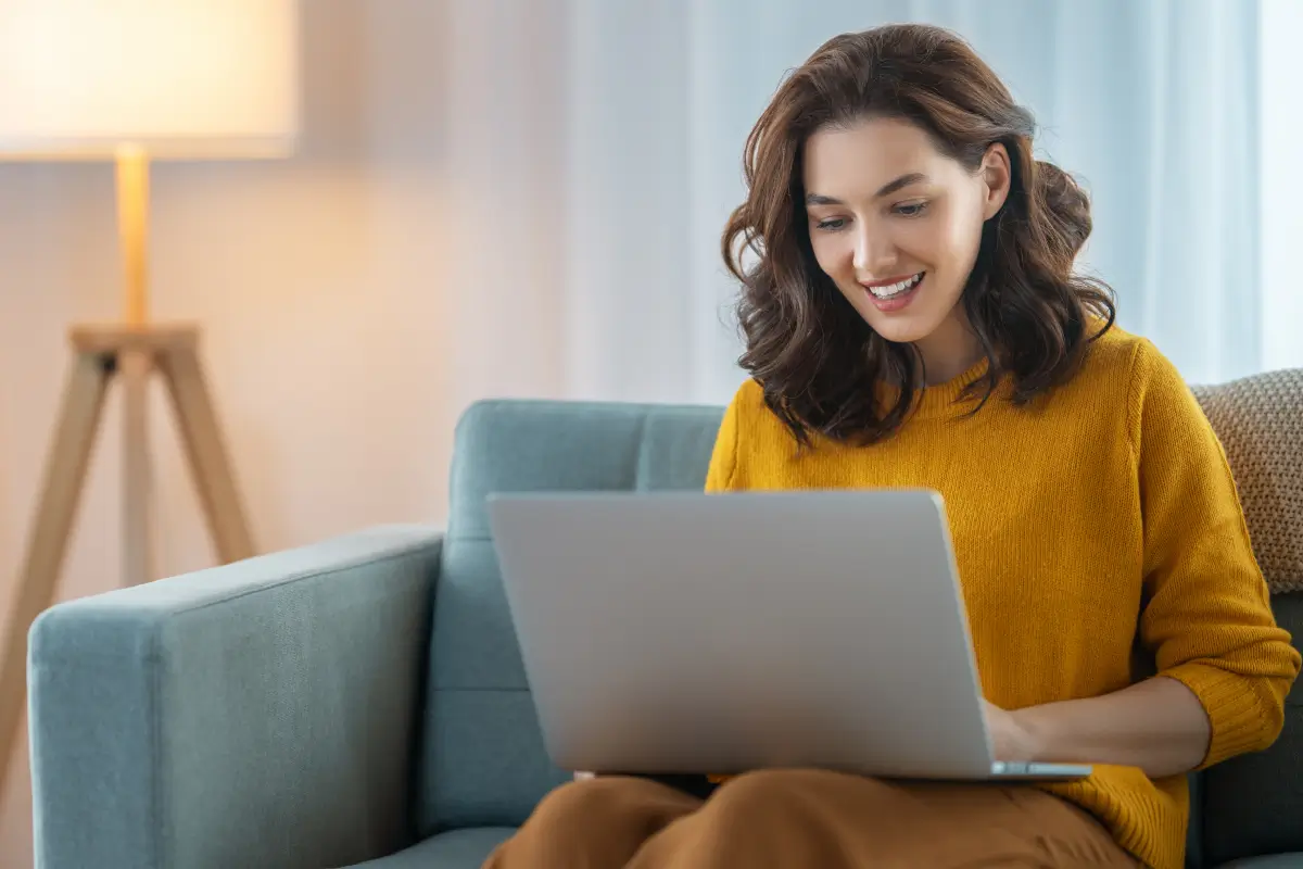 A woman enjoys the internet on her laptop.