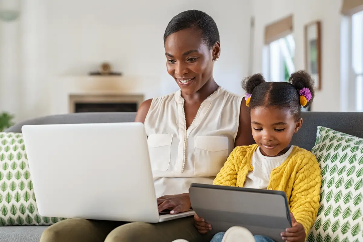 A mother and daughter surf the web simultaneously on two different laptops using Verizon 5G Home Internet.