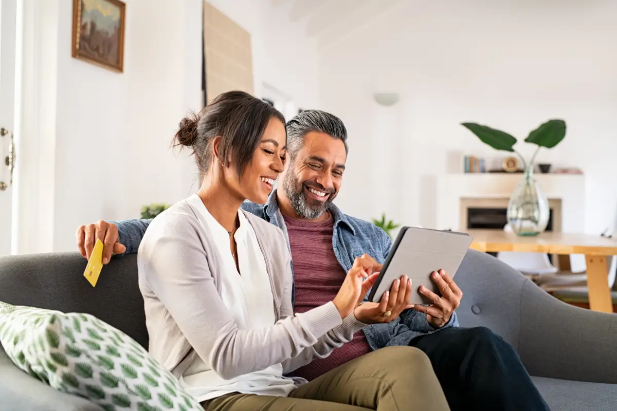 A husband and wife enjoy the internet on a tablet.