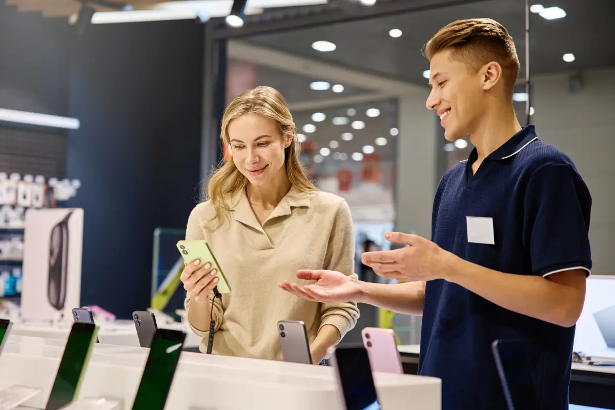 A salesperson helps a customer shop for a new smartphone.