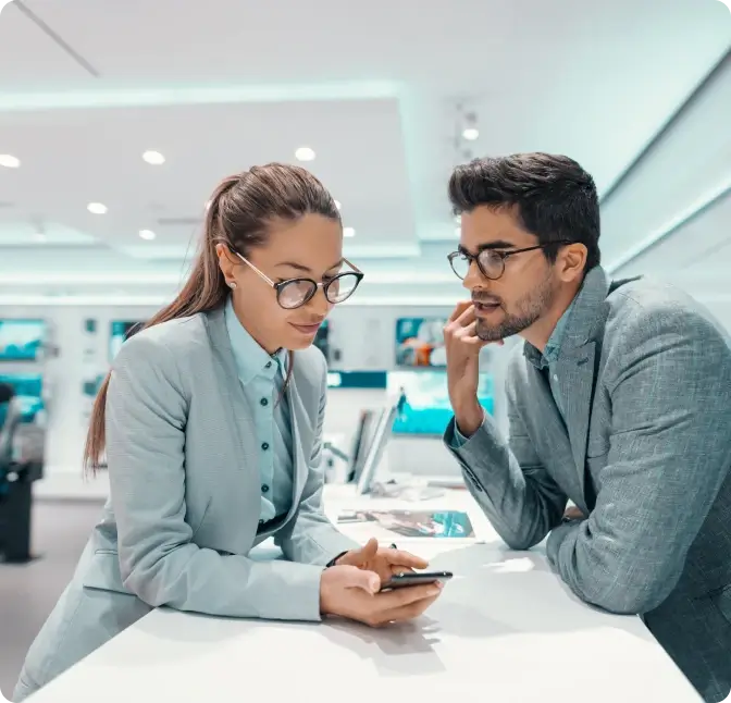 A man and woman discuss the features of a new smartphone at the Verizon store.