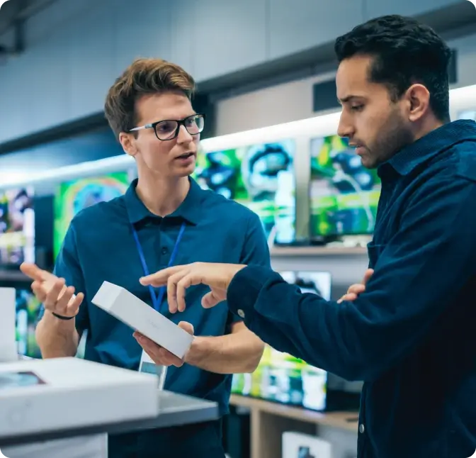 Sales associate assists a man shopping for a smartphone.